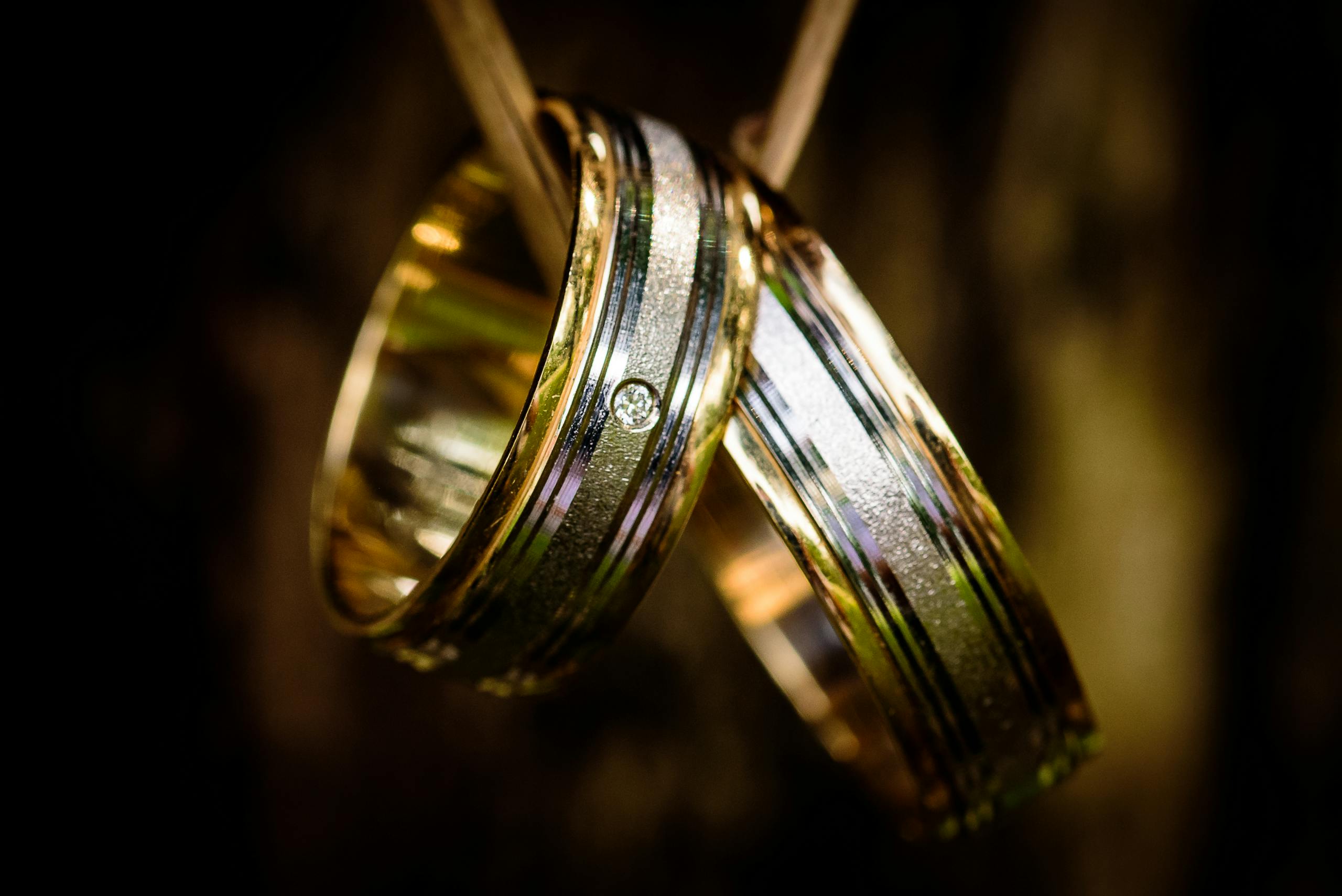 Close-up of luxurious gold wedding rings with a diamond detail, perfect for wedding themes.